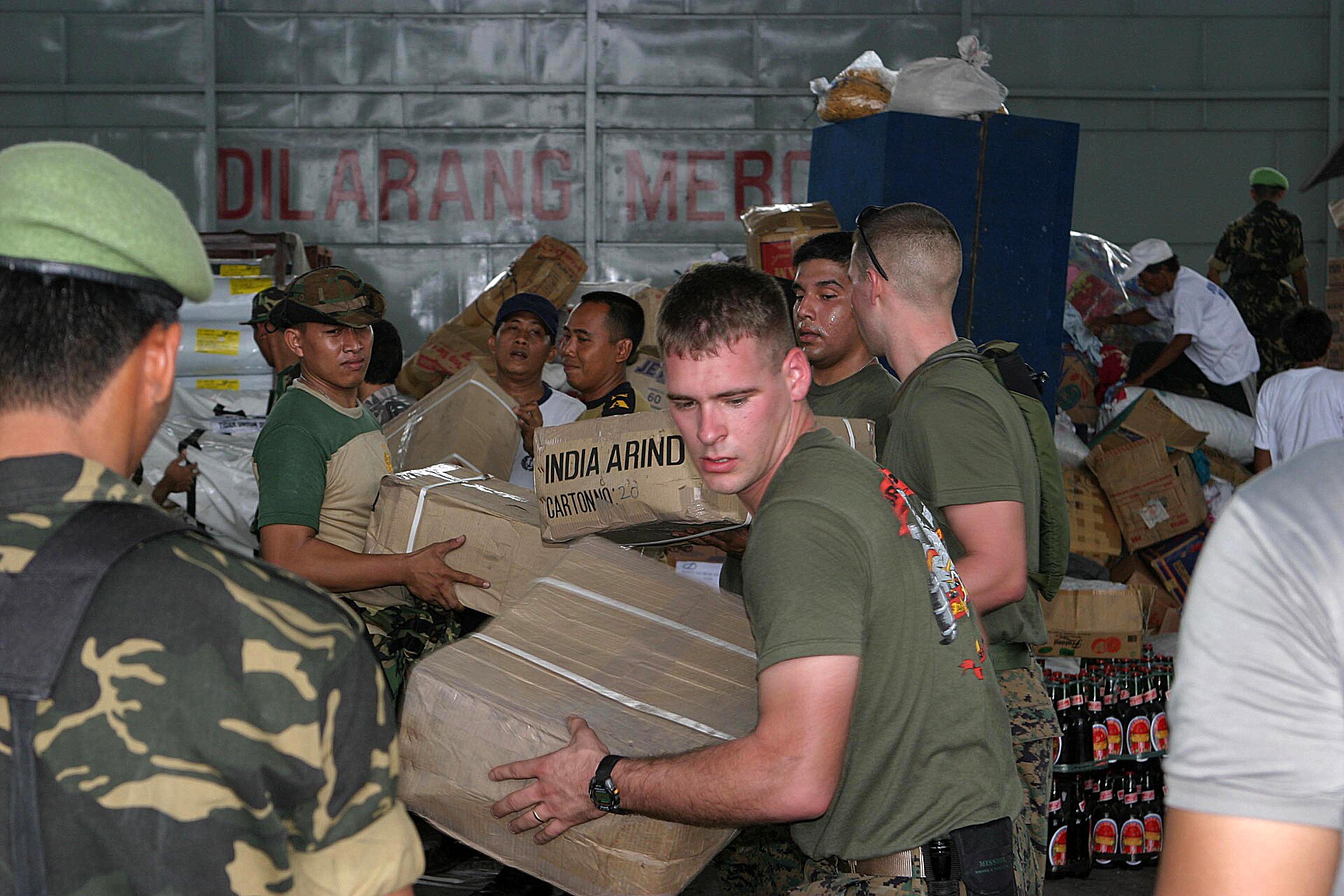 Personel marinir AS, TNI, dan pekerja bantuan menyortir logistik bantuan tsunami di Medan, Januari 2005